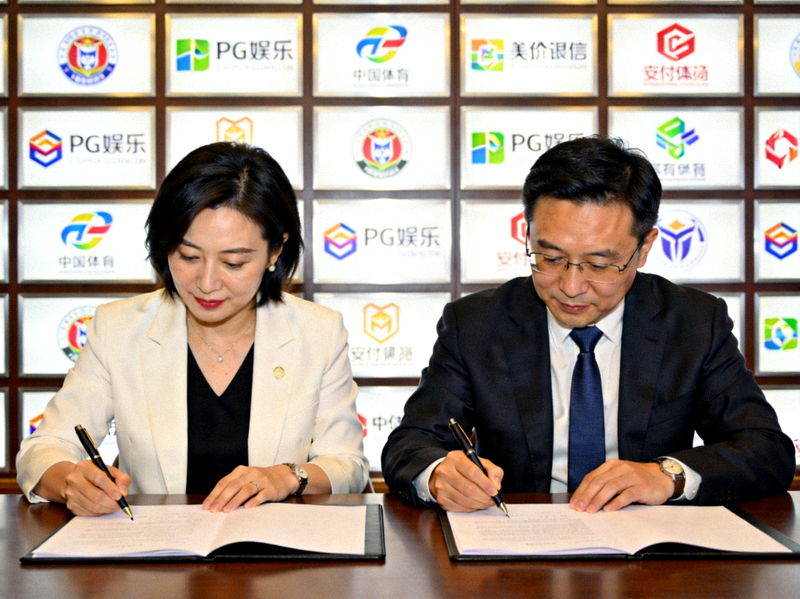 PG娱乐与合作伙伴签约仪式现场，双方代表在合作协议上签字，背景是合作项目的Logo墙